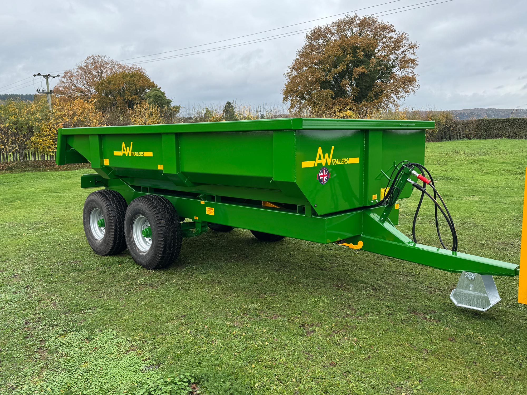 Smaller green agricultral trailer in a grass field