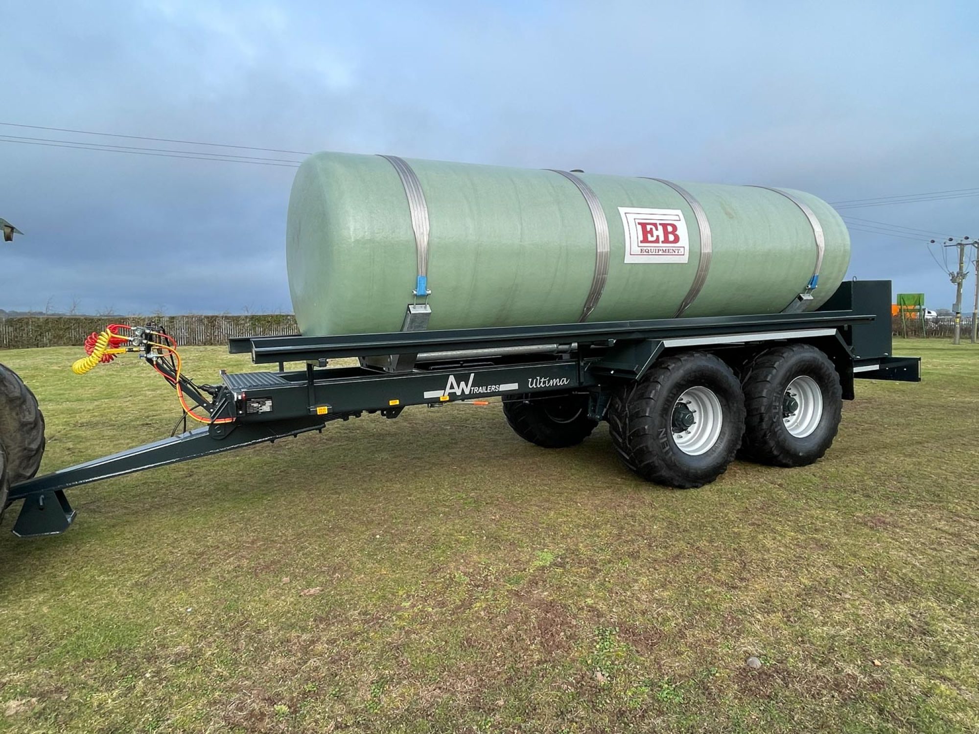 A large green tank in a field being carried on a trailer