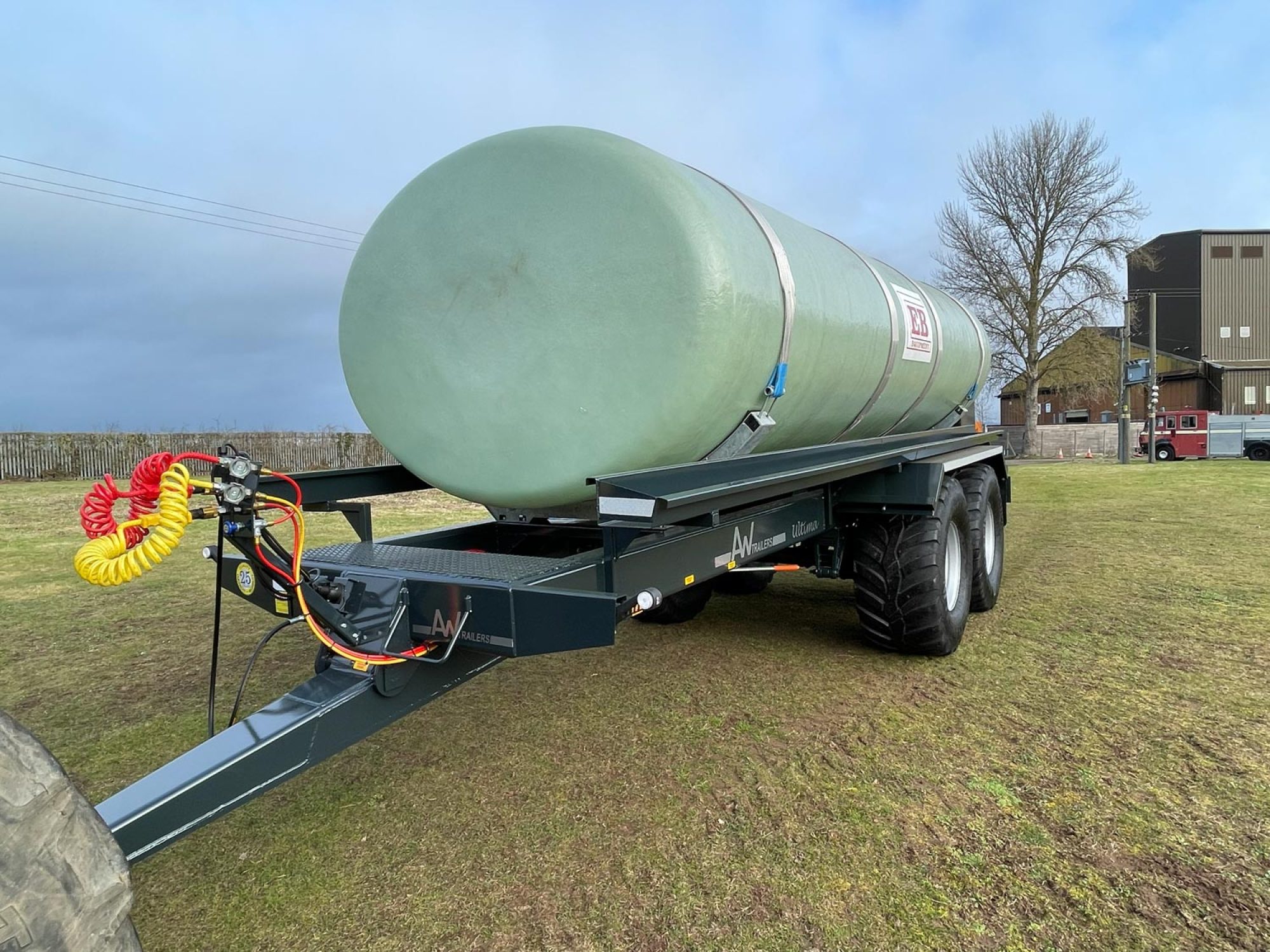 A large green tank in a field being carried on a trailer