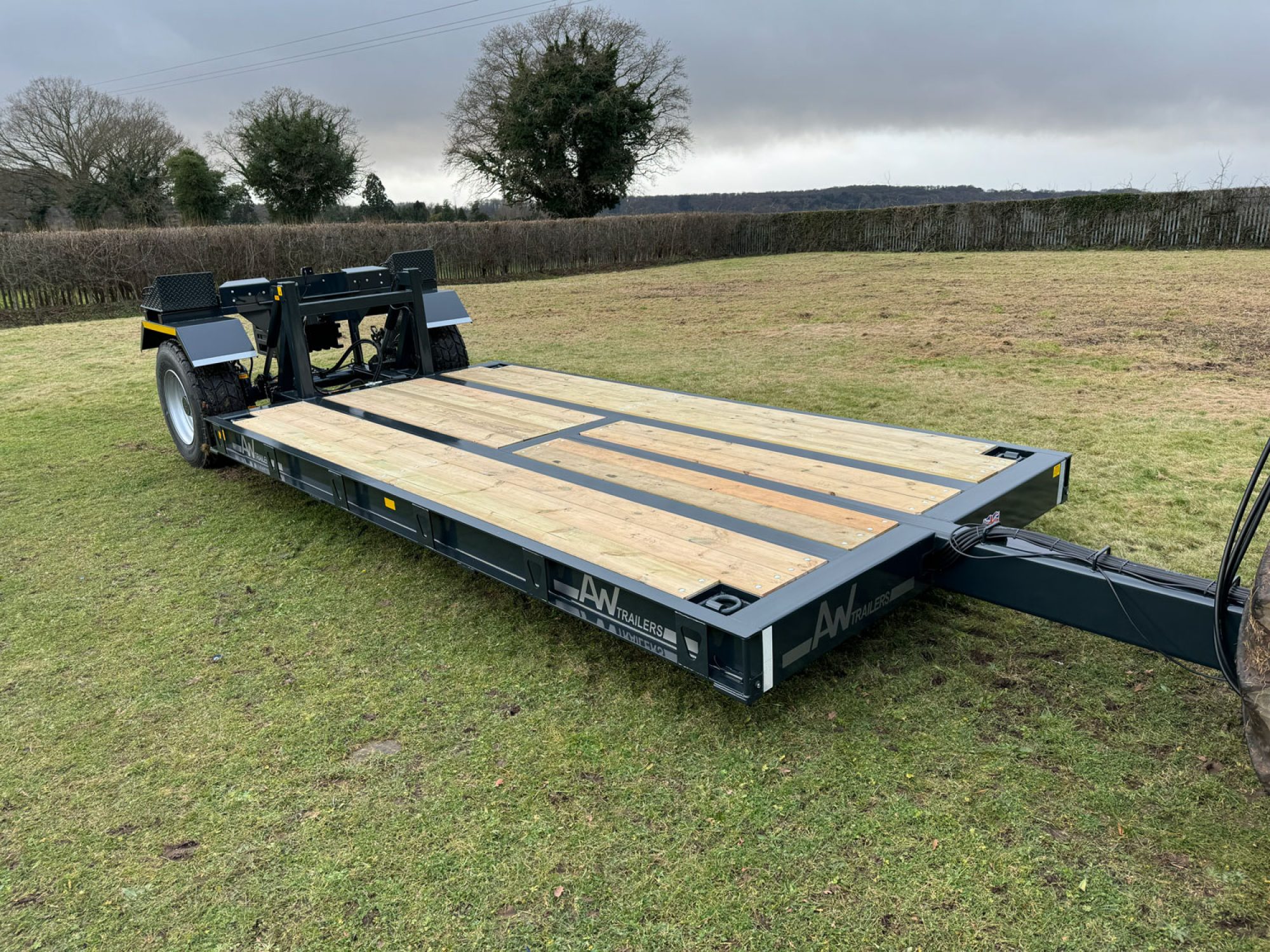 Black flatbed trailer in a field