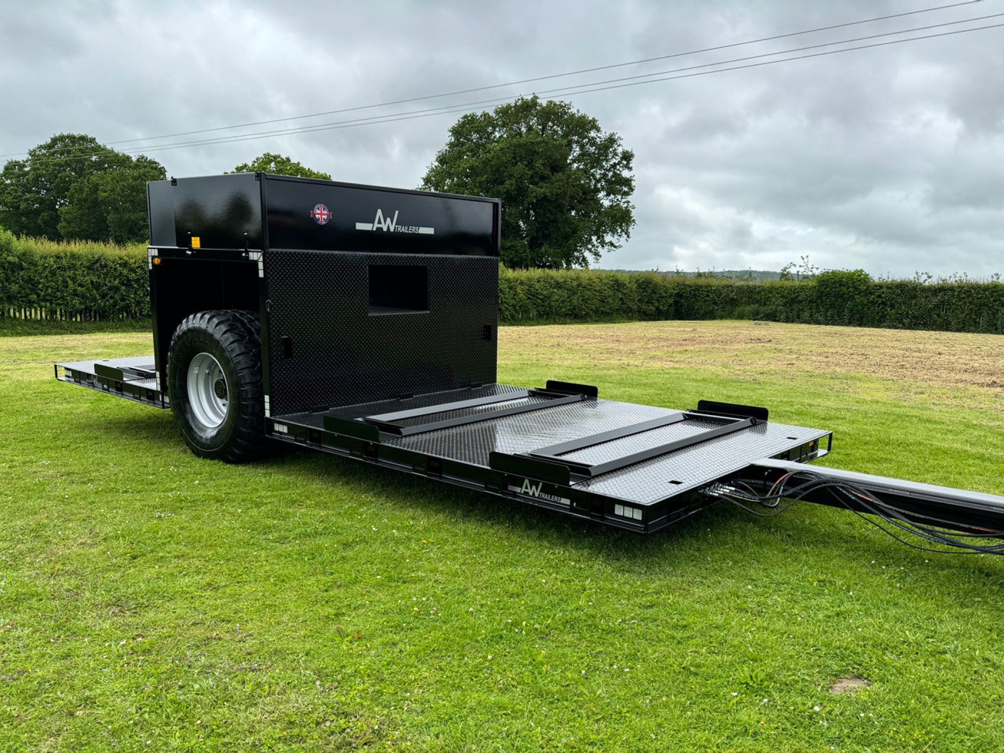 Black flatbed trailer in a field