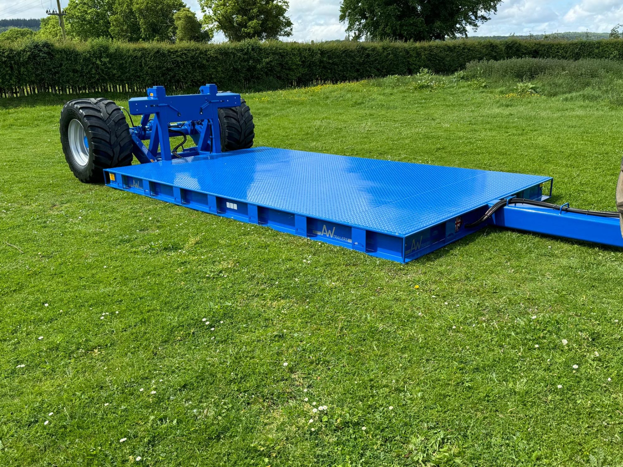 Blue flatbed trailer in a field