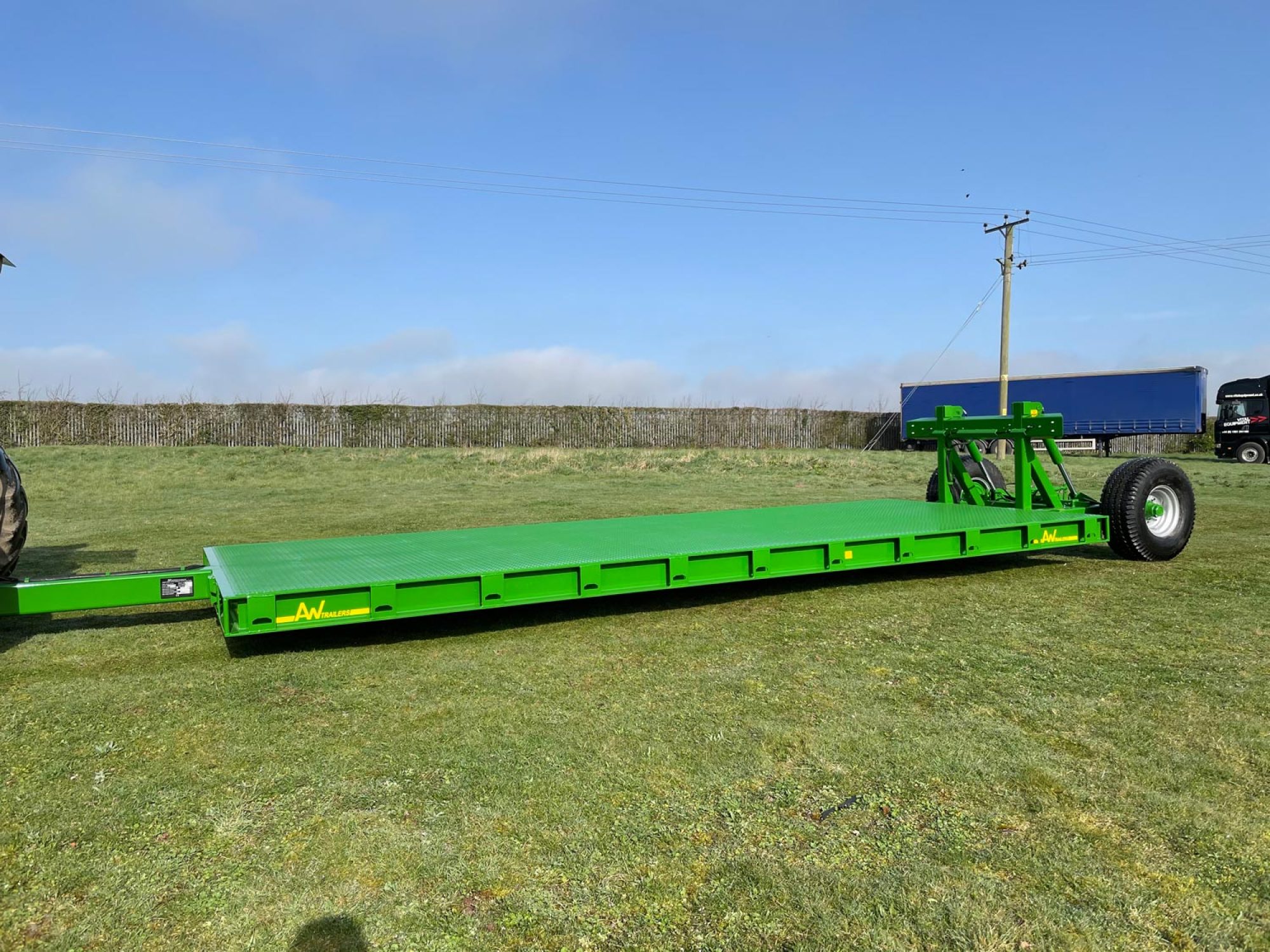 Green flatbed trailer in a field