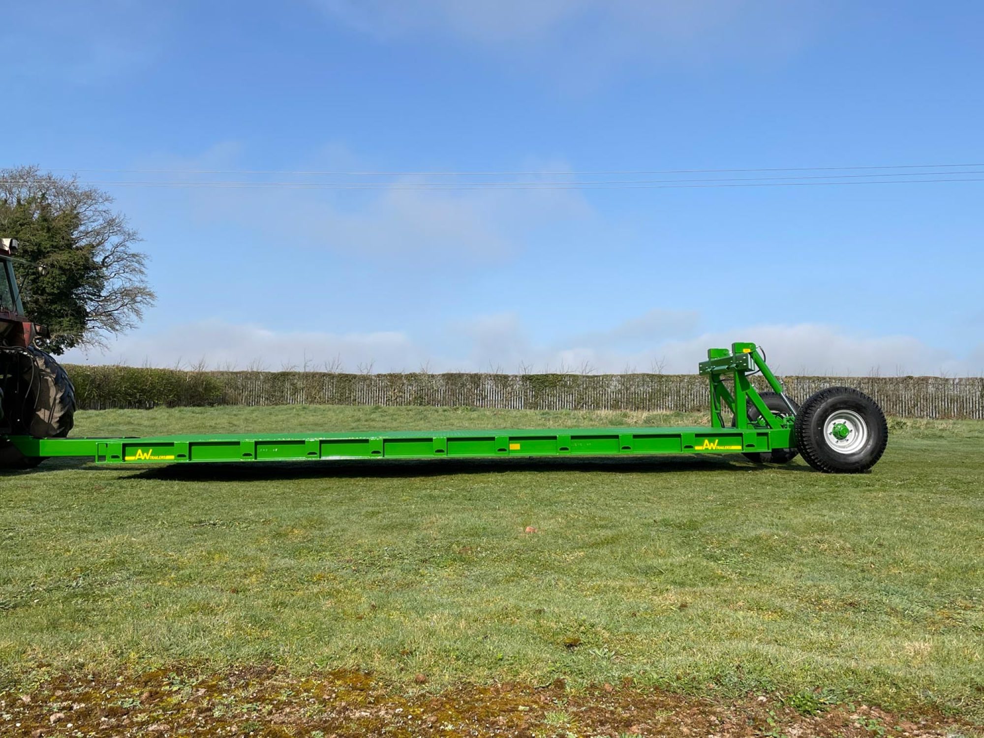 Green flatbed trailer in a field