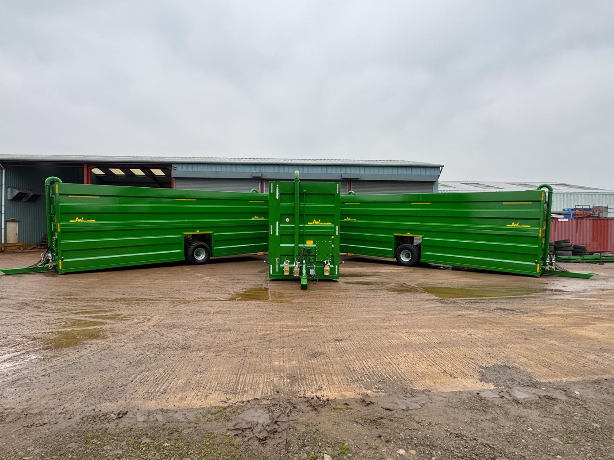 3 large green tanks in a parking lot in a factory