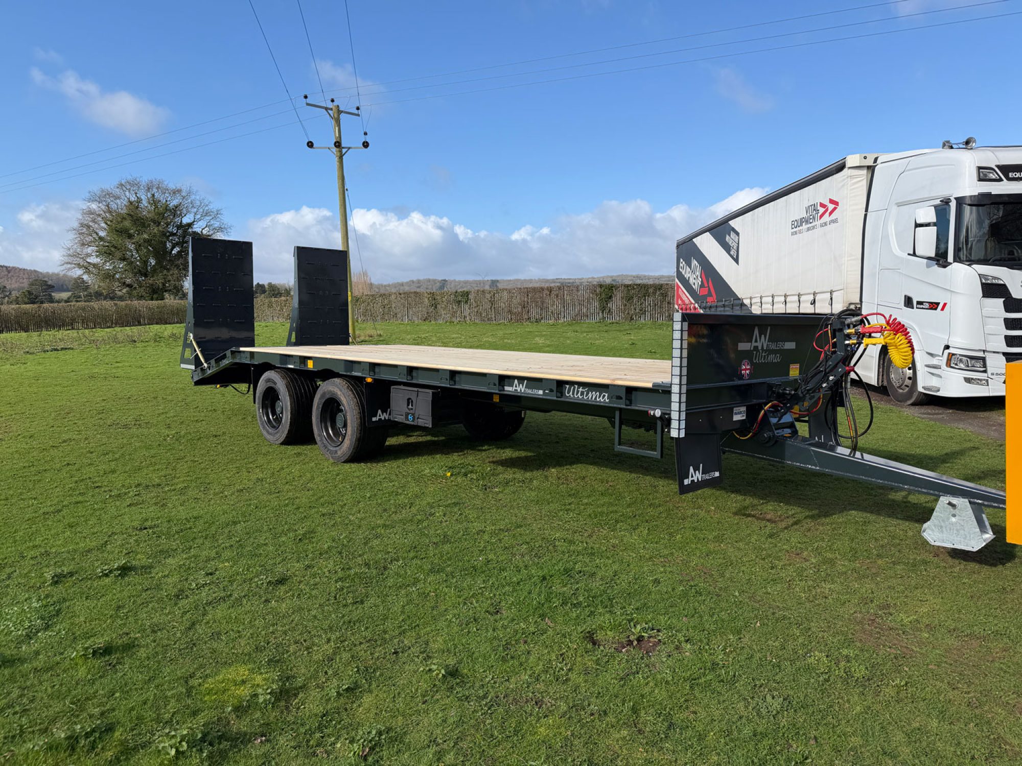 Black plant low loader trailer in a field