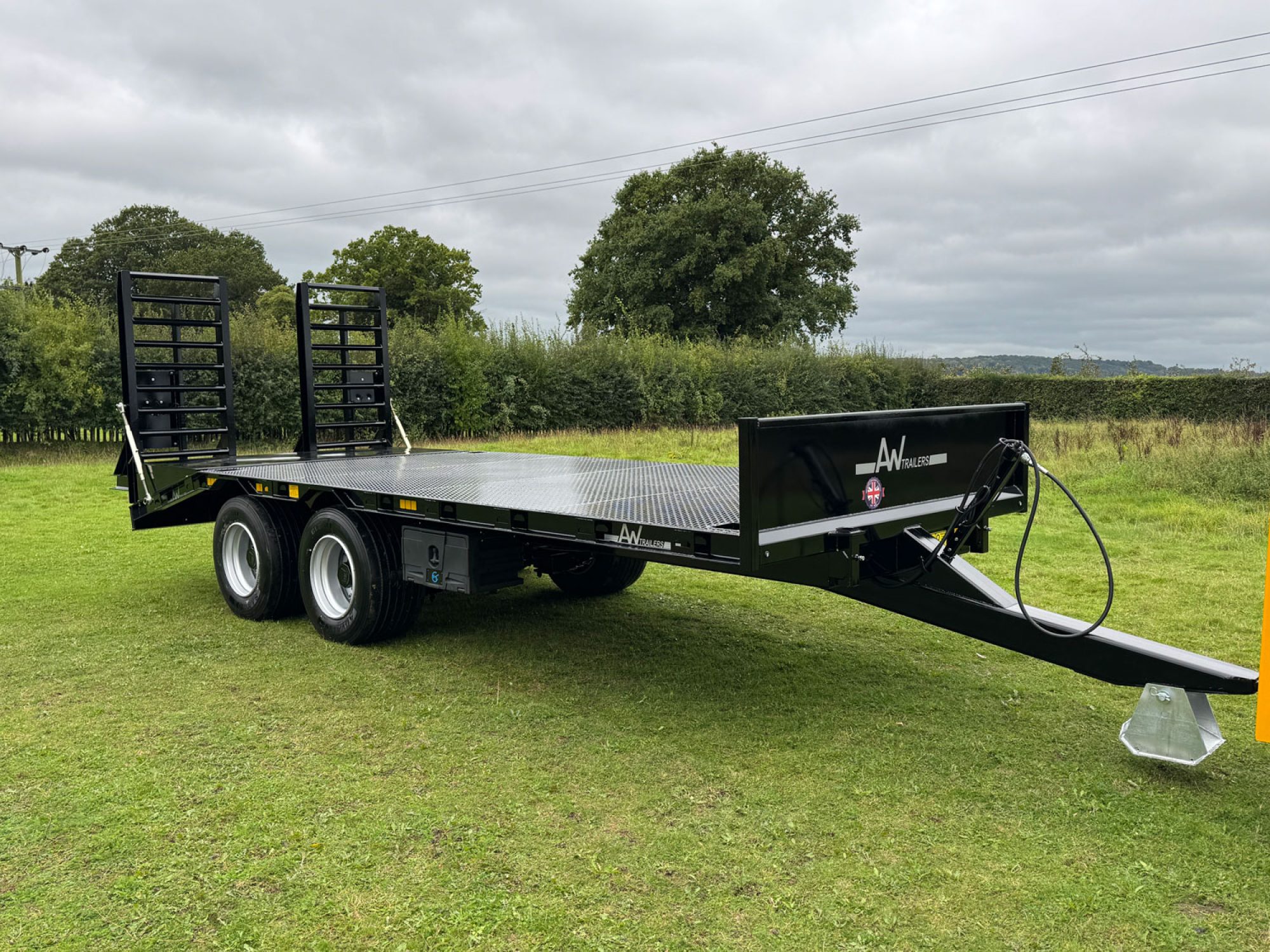 Black plant low loader trailer in a field