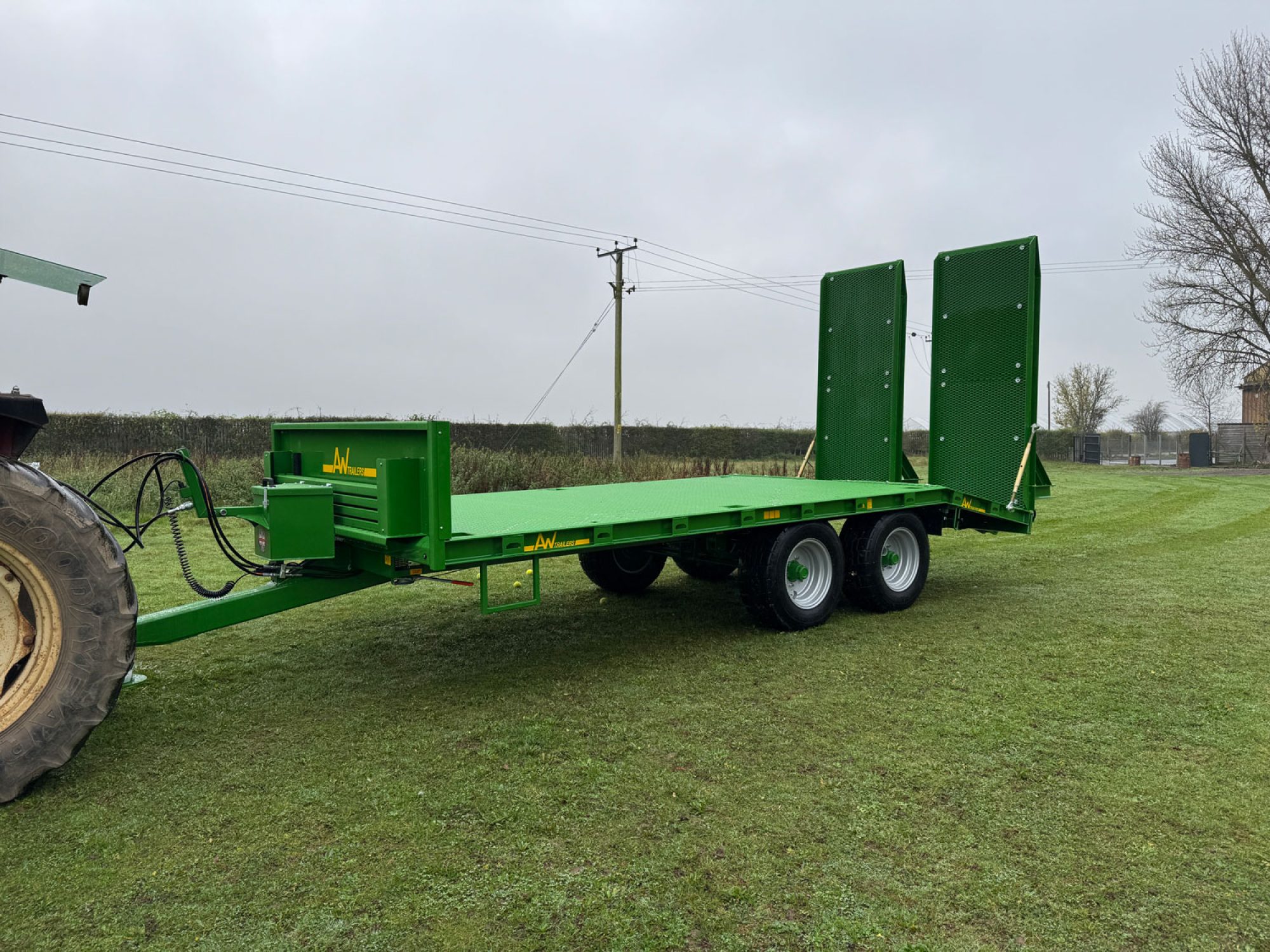 Green plant low loader trailer in a field