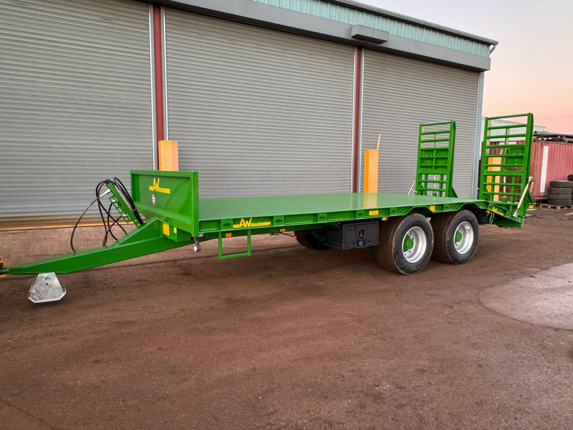 Green plant low loader trailer in a carpark