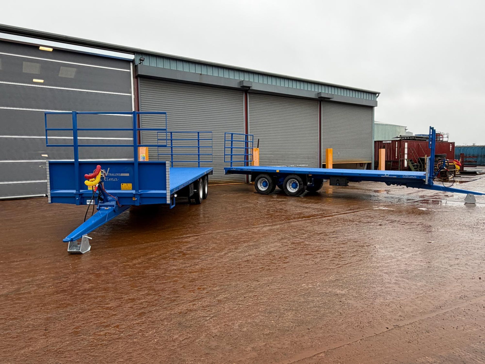 2 Blue bale trailers in a field