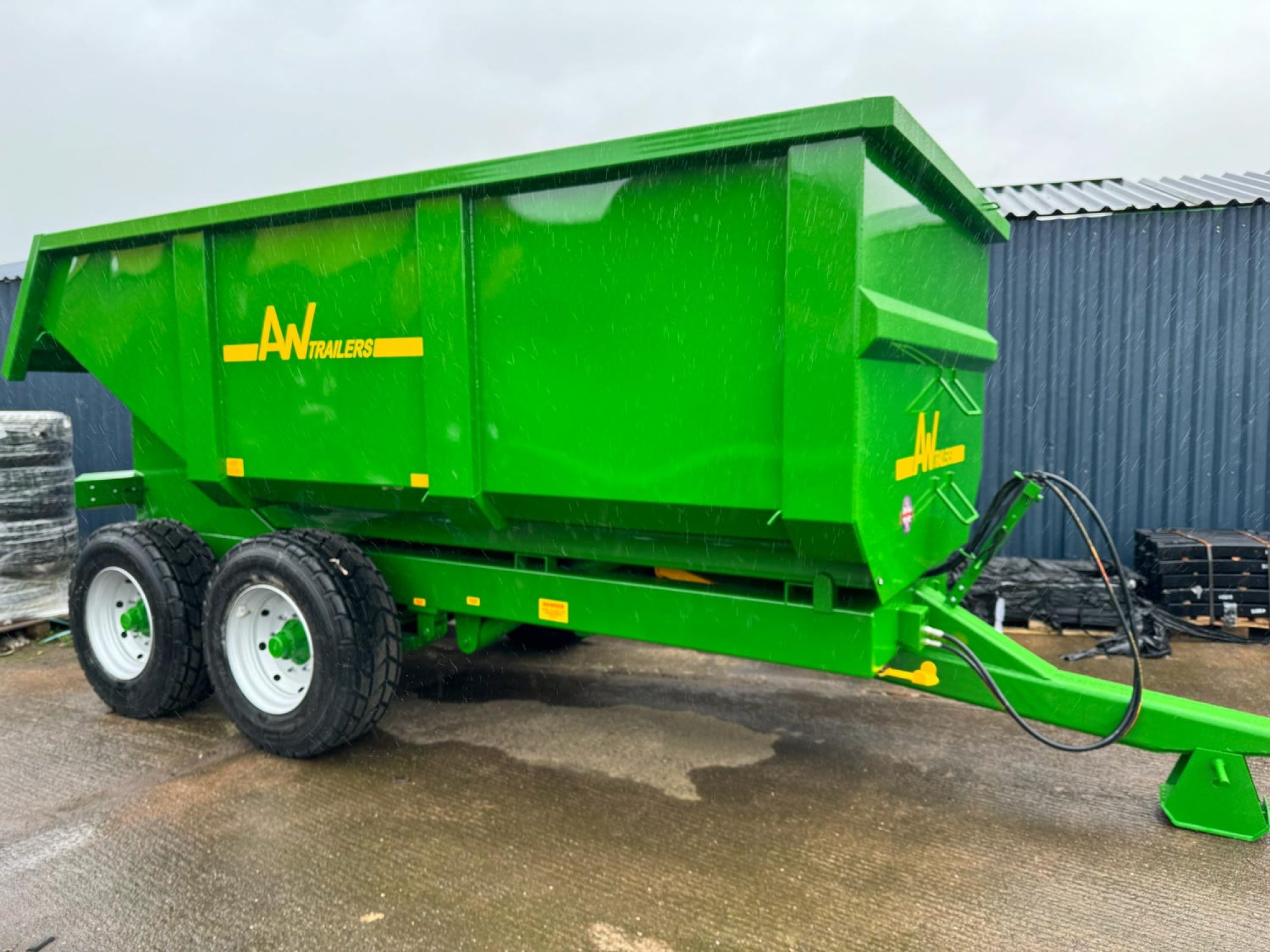 A large green trailer in a factory car park