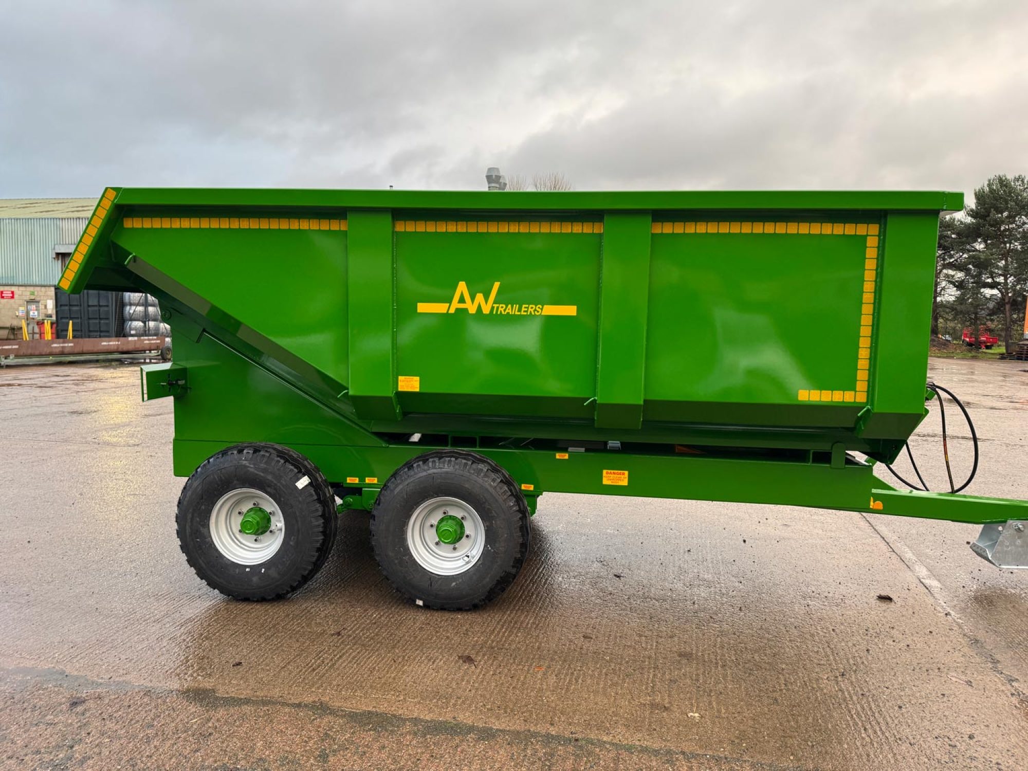 A large green trailer in a factory car park