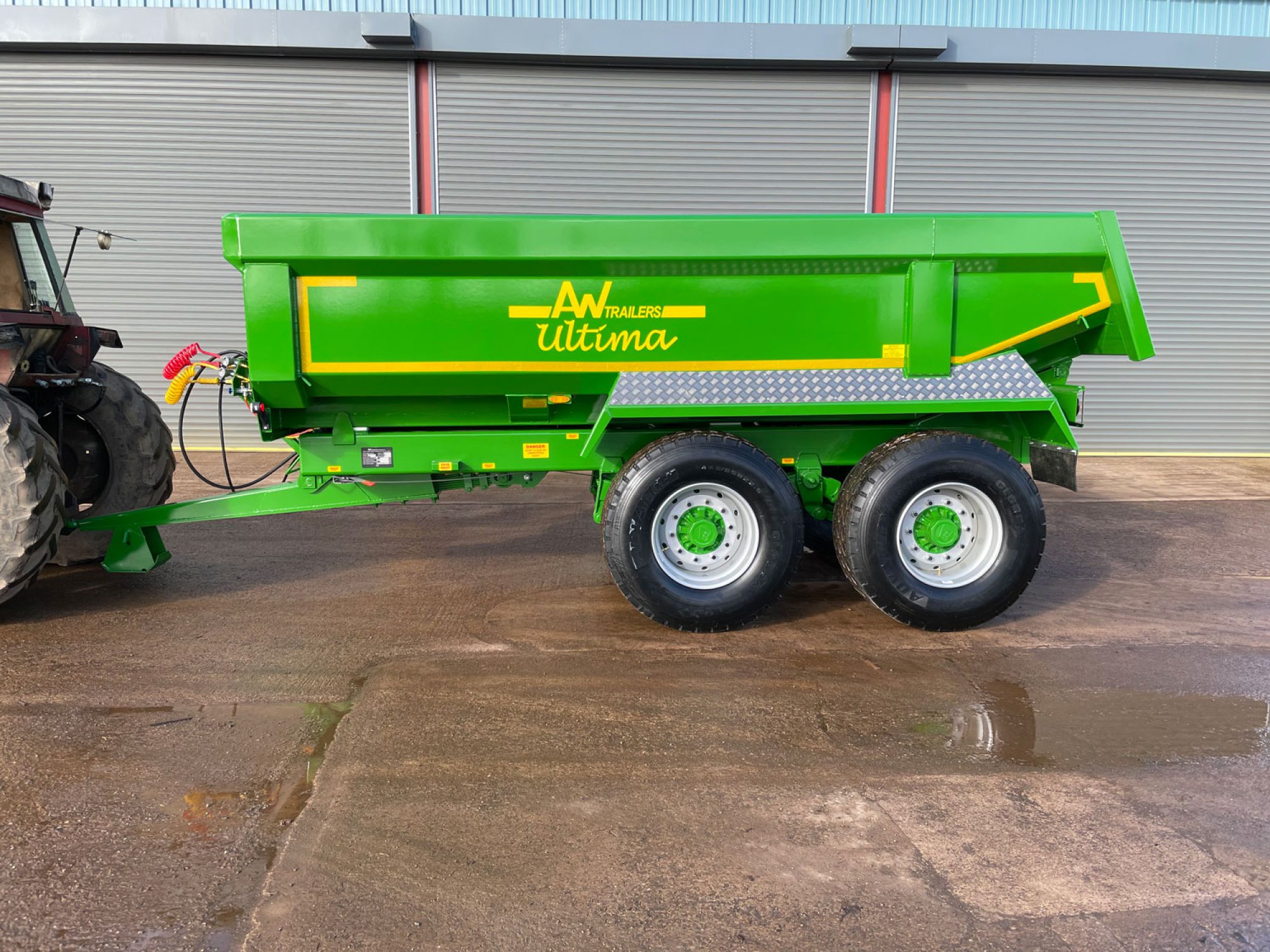 Side profile of a green trailer in a car park