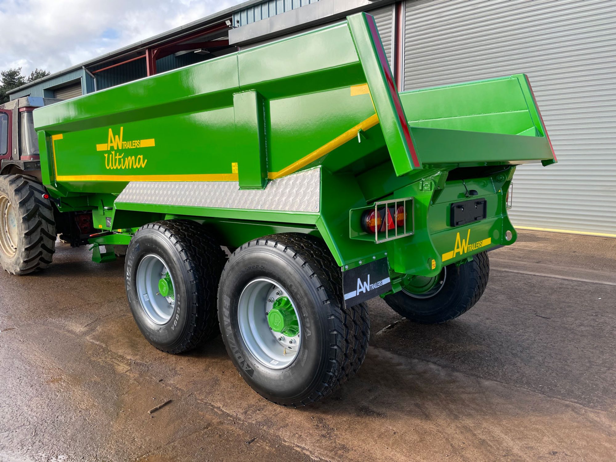 Side profile of a green trailer in a car park