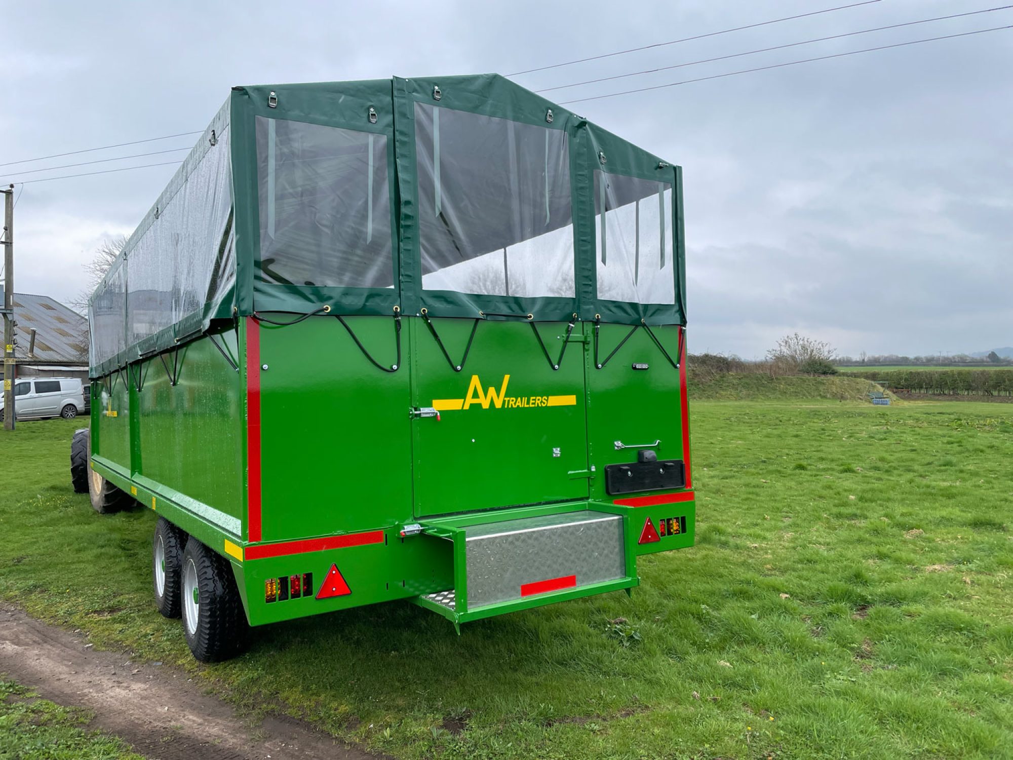 Back of a green people carrier trailer in a field