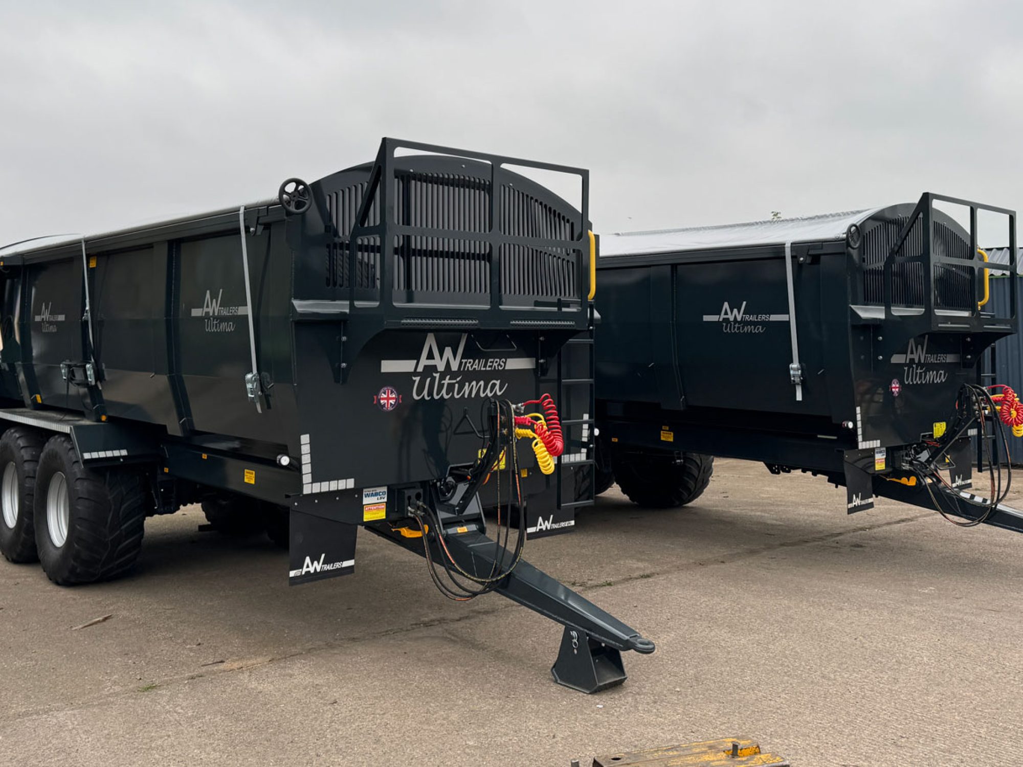 2 large black ultima monocoque trailers in a factory carpark
