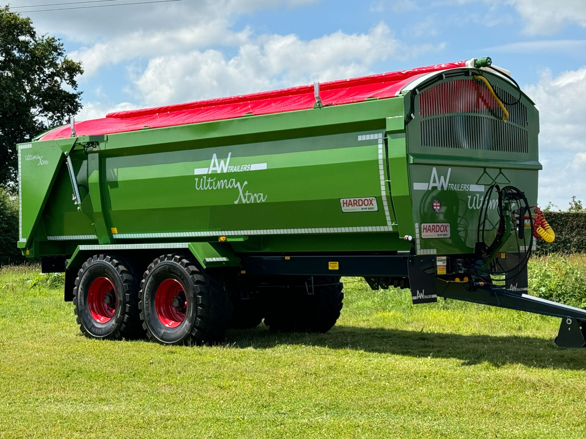 A large green ultima monocoque trailer in a field